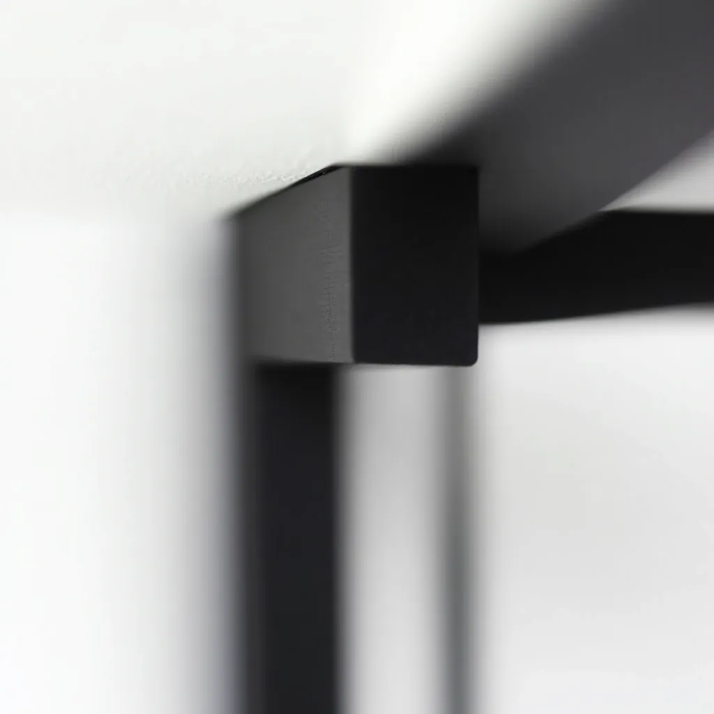 Close-up detail of matte black steel frame corner joint showing powder-coat finish quality and solid construction